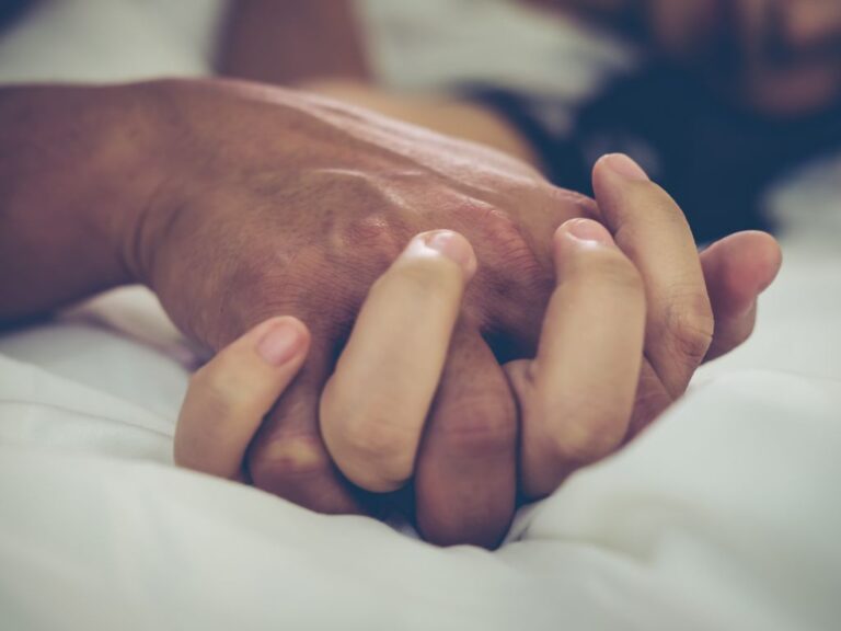 mulher e homem com as mãos entrelaçadas