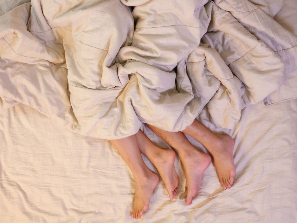 pernas de um casal na cama