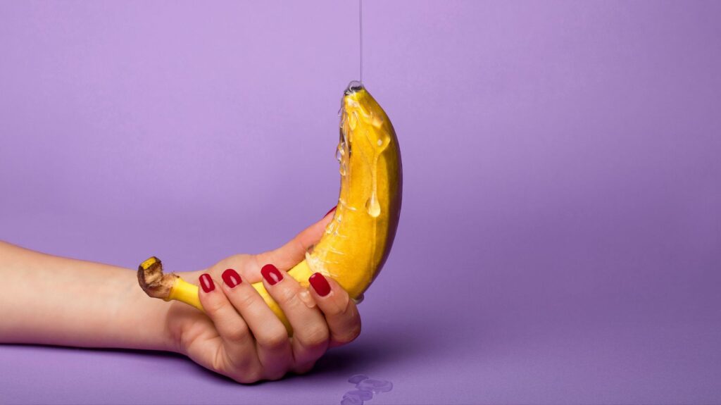 banana com lubrificante para remeter a um pênis com lubrificante