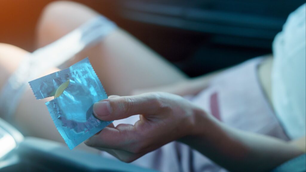 mulher entregando camisinha para fazer sexo no carro