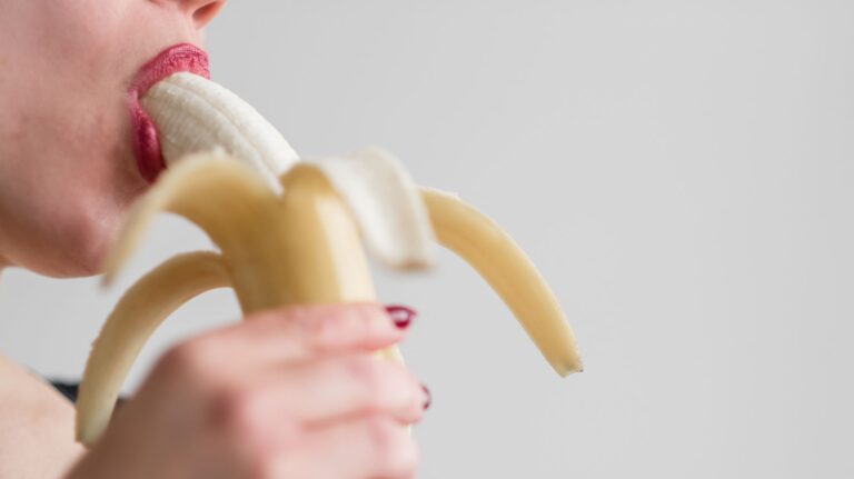 mulher com banana na boca para ilustrar um post sobre cuspir ou engolir esperma