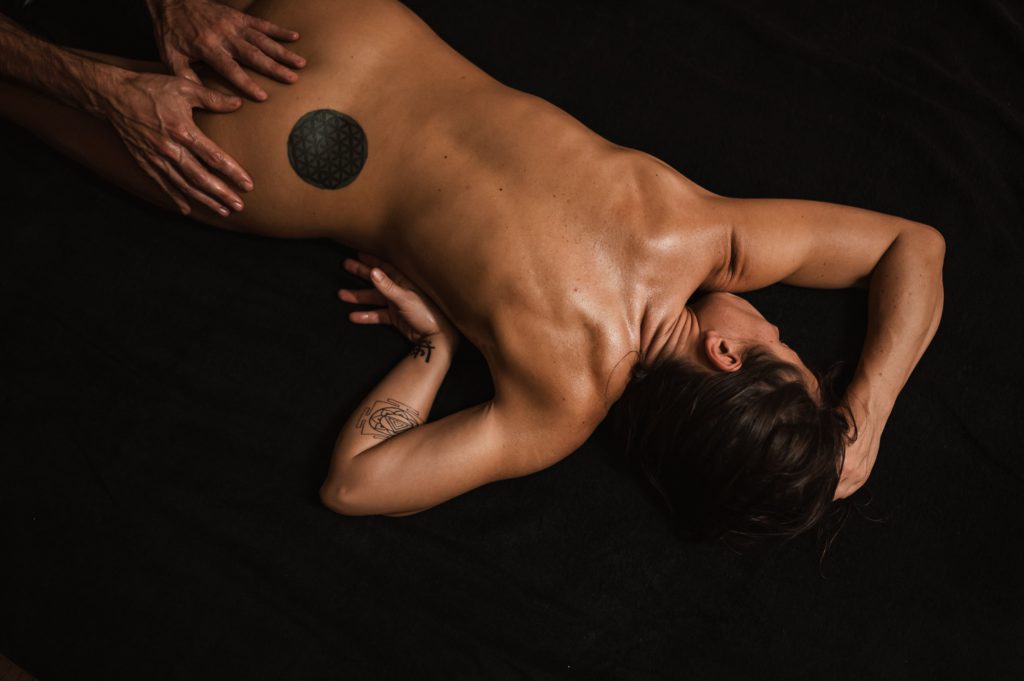 Mulher nua sendo massageada. Imagem disponível em Unsplash.