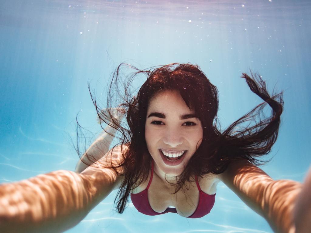 mulher debaixo d'água sorrindo