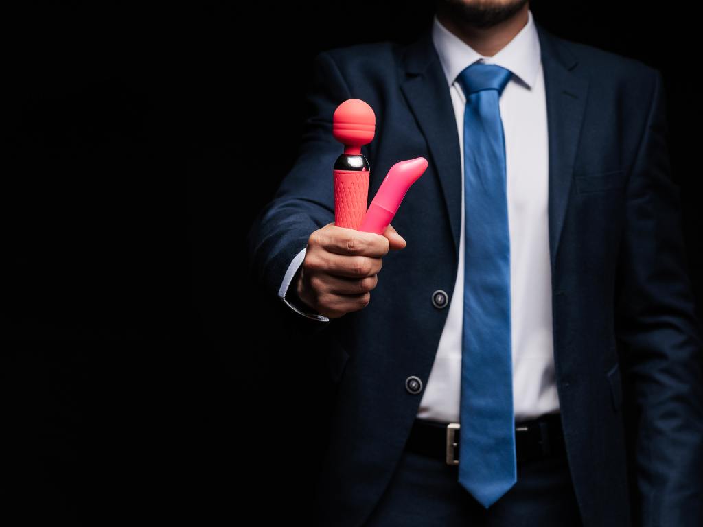 Homem segurando brinquedos eróticos