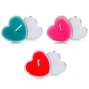 Três velas corporais nas cores azul, rosa e vermelho. As três em formato de coração. 
