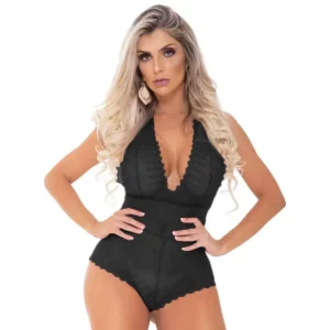 Mulher loira usando body preto com renda, com as mãos na cintura.