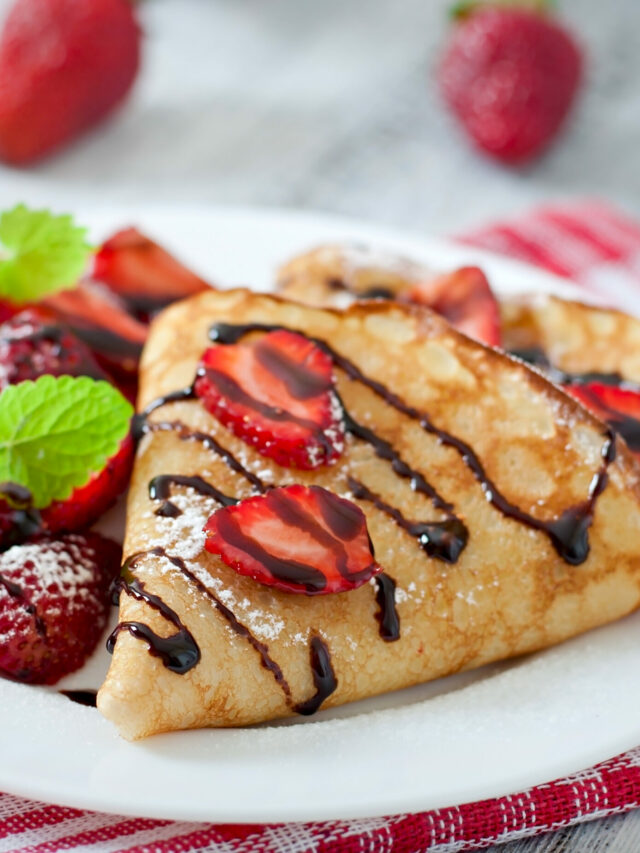 Pancakes with strawberries and chocolate decorated with mint leaf