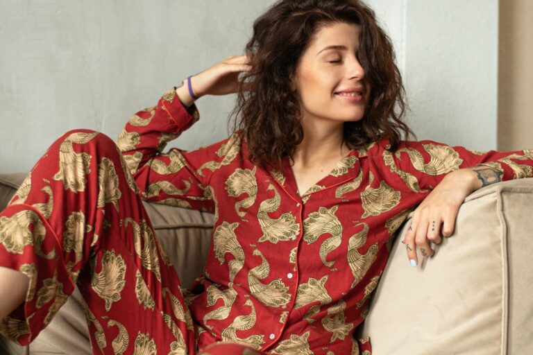 mulher vestindo modelo de pijama com camisa com manga longa e calça longa vermelho com detalhes em amarelo