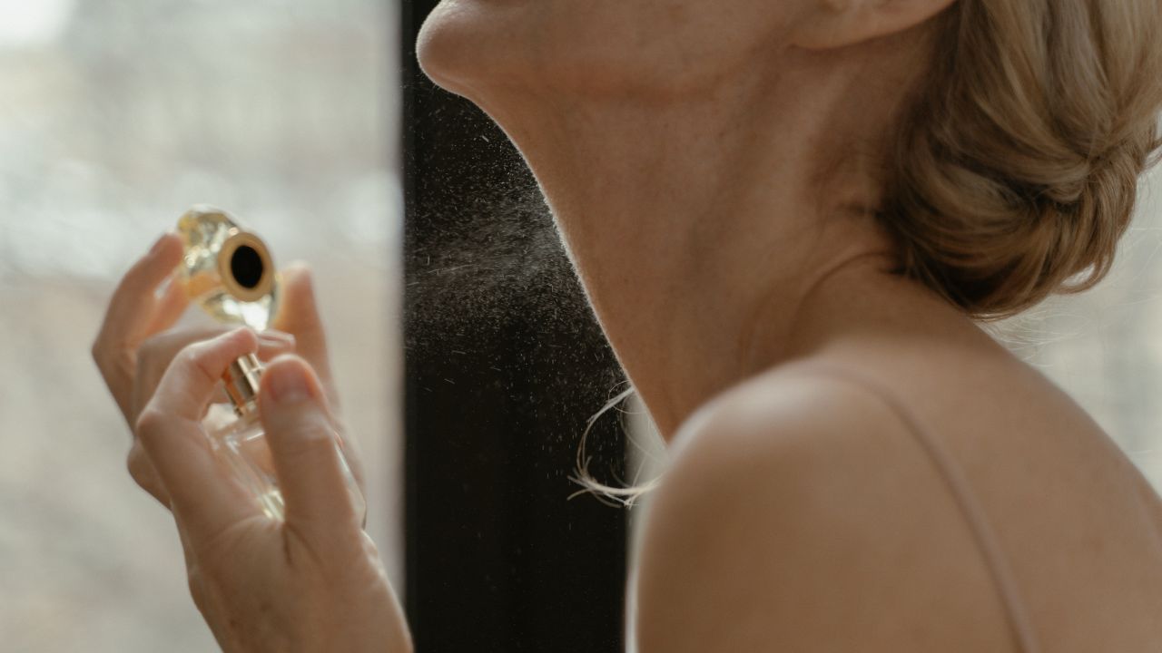 imagem de uma mulher loira usando um perfume