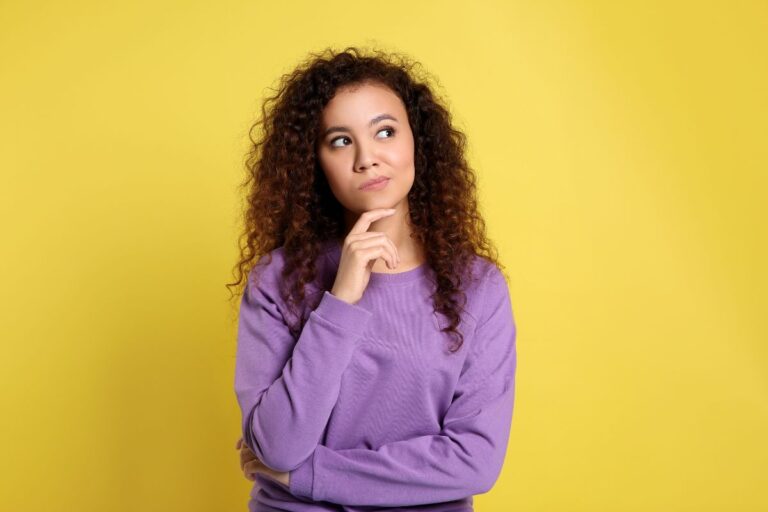 mulher com expressão de dúvida em um fundo amarelo