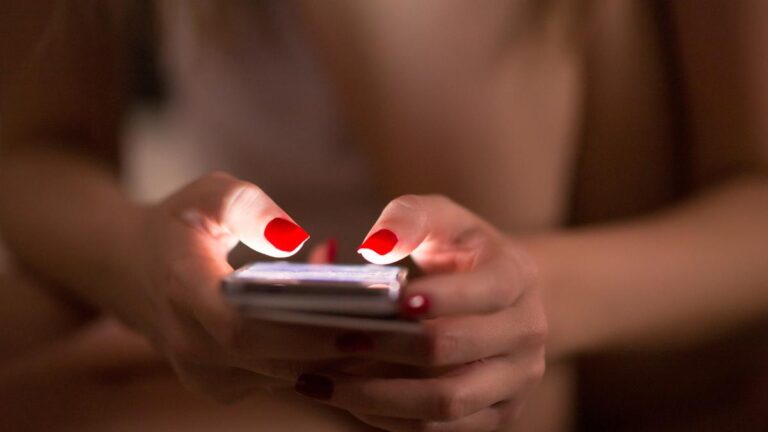 Mulher com celular na mão para trocar nudes