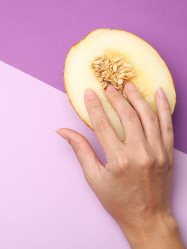 uma mão tocando com melão cortado em um fundo roxo