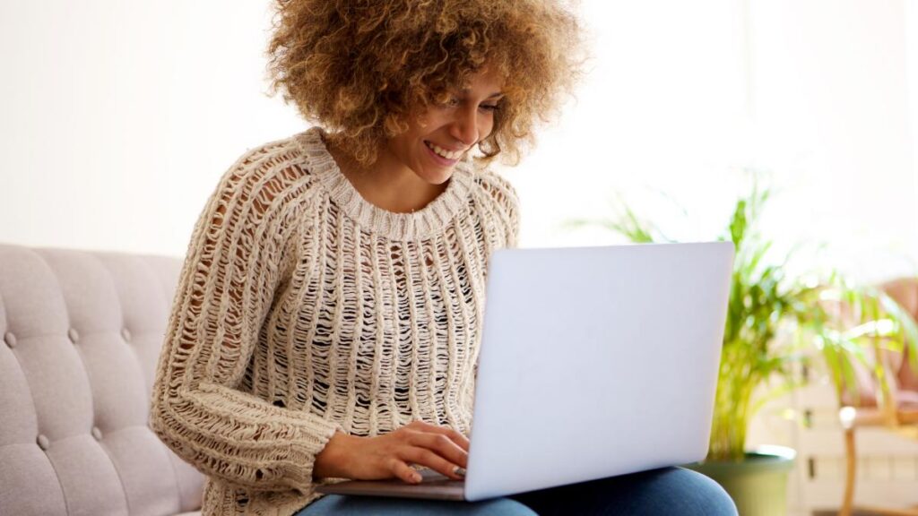 Mulher usando computador para se cadastrar e revender Jequiti.