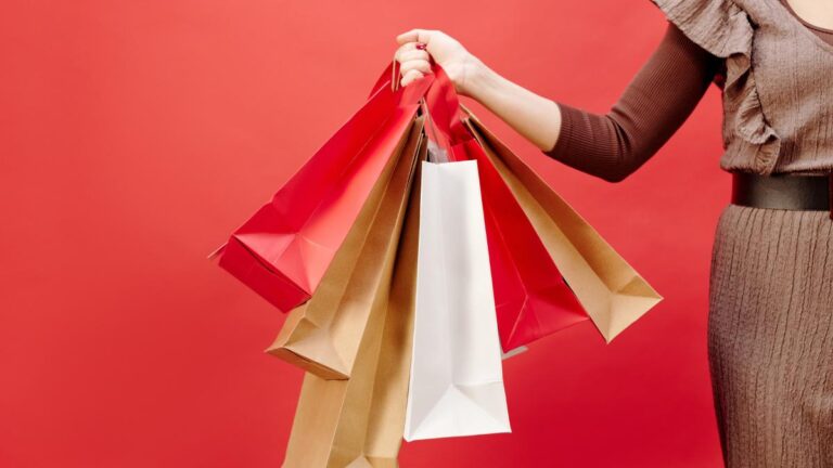 Mulher segurando sacolas de produtos para comprar e revender.