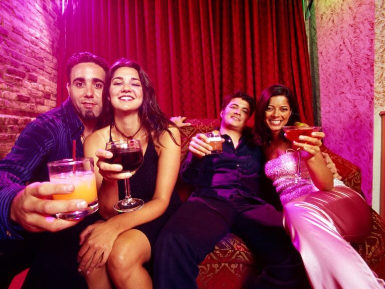 dois casais em uma balada com taças nas mãos