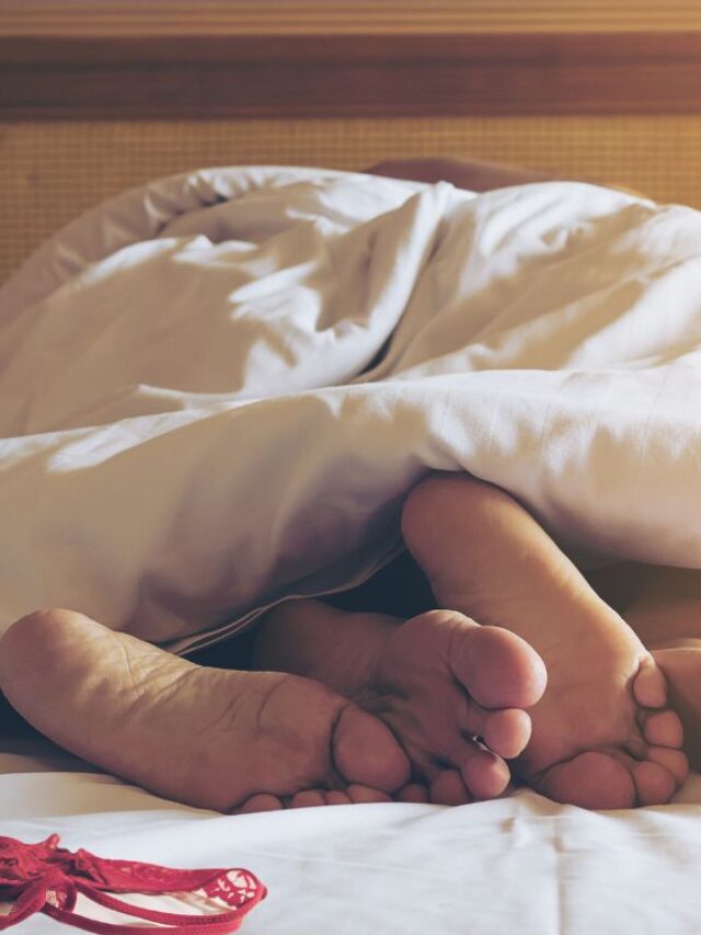pés de um casal na cama e uma calcinha de lado
