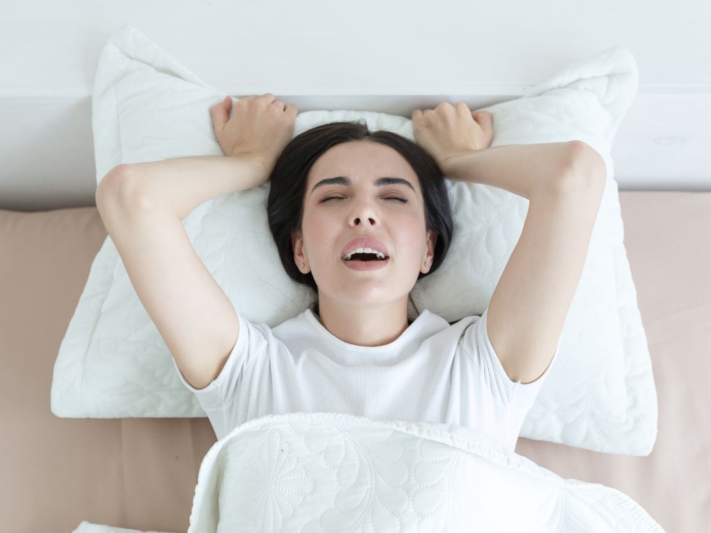 mulher segurando travesseiro tendo um orgasmo