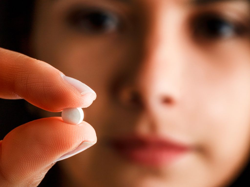 mulher segurando pílula do dia seguinte
