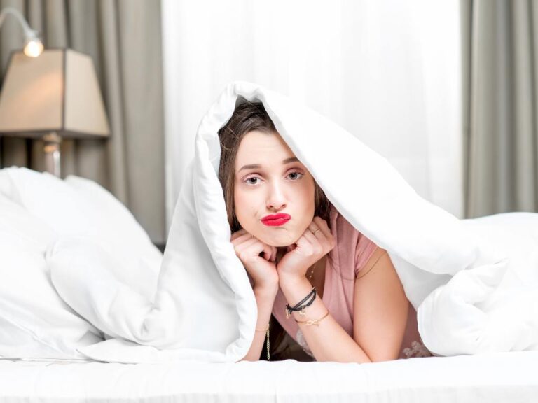 Mulher deitada na cama com insatisfação