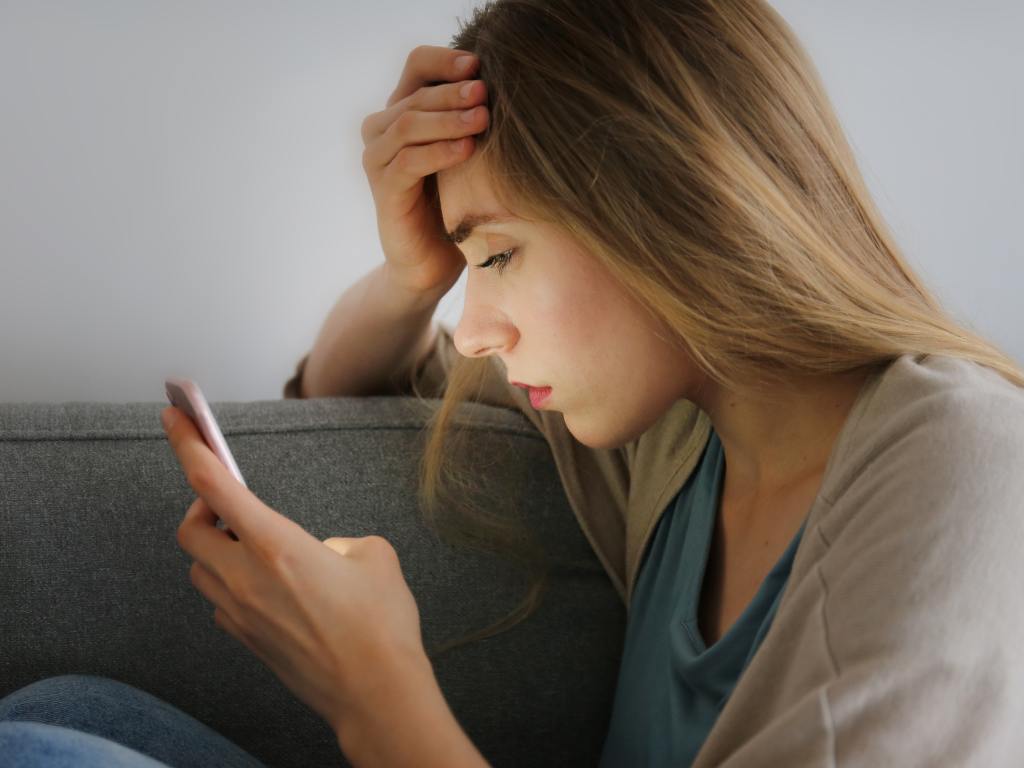 Mulher frustrada olhando para celular