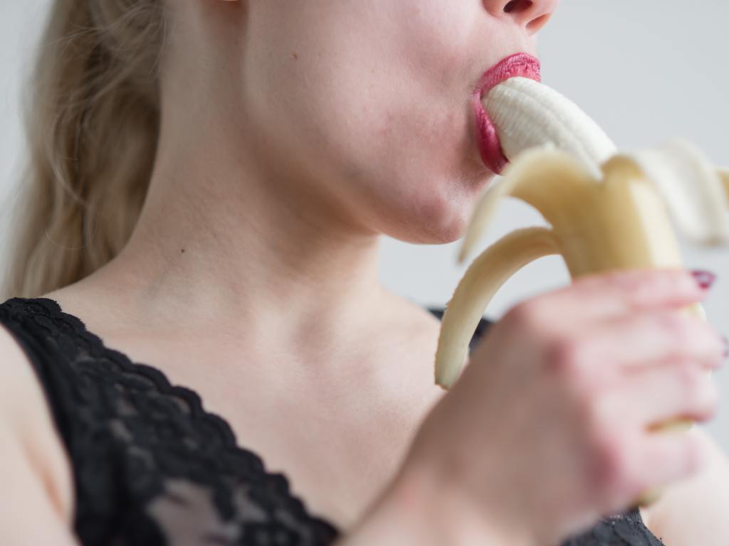 mulher chupando banana simulando sexo oral