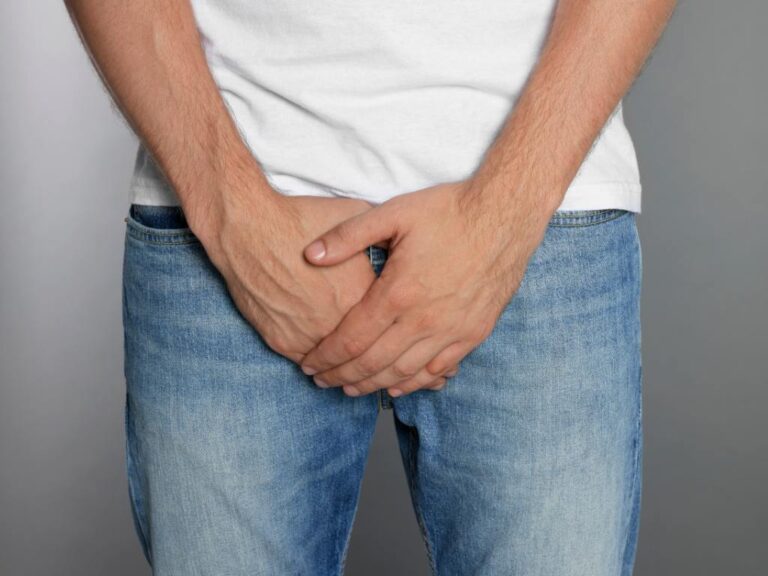 Homem cobrindo região íntima