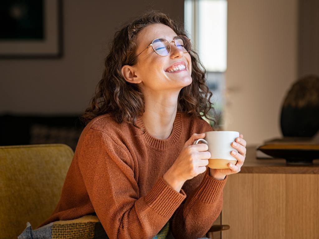 Mulher segurando caneca e sorrindo