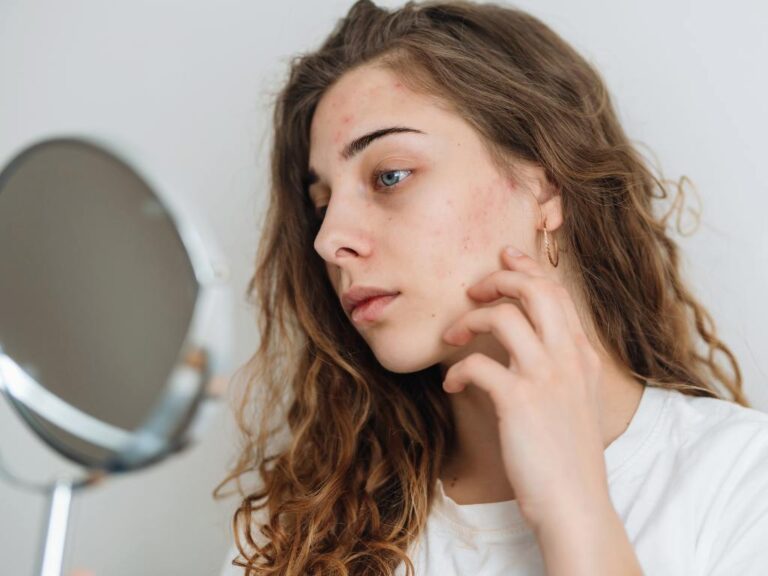 Mulher olhando sua pele sensível