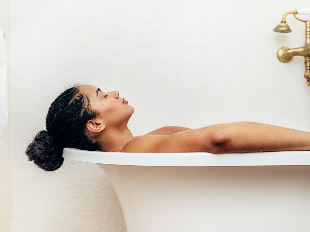 Mulher dentro de banheira relaxando