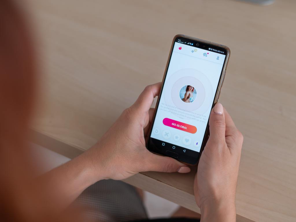 Mulher mexendo no Tinder em seu celular
