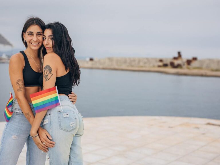 Casal lésbico segurando bandeira LGBT