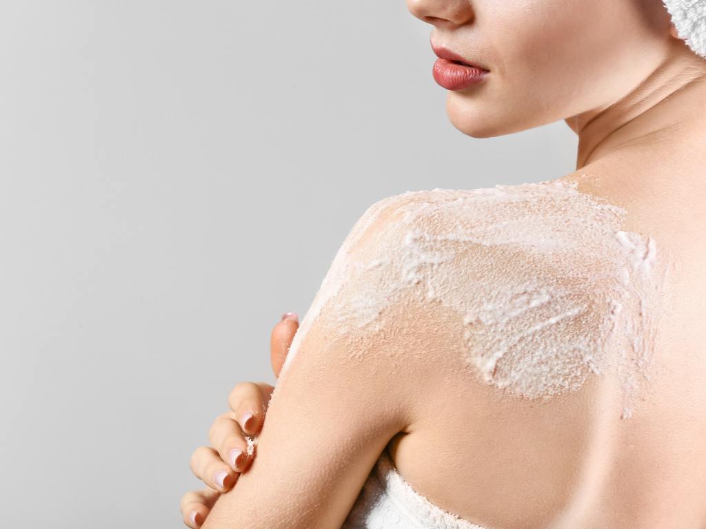 Mulher fazendo esfoliação corporal
