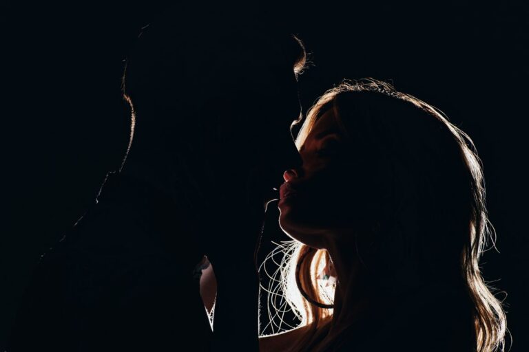casal se beijando no escuro em um motel para swing
