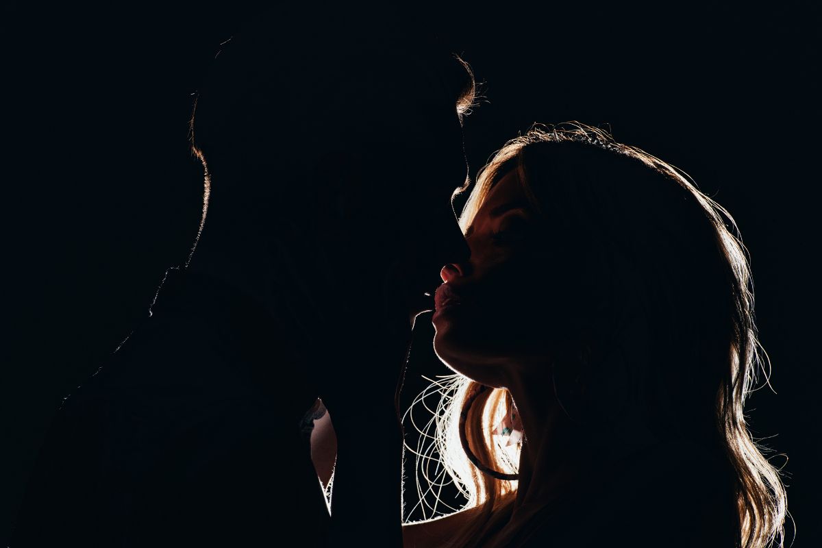 casal se beijando no escuro em um motel para swing