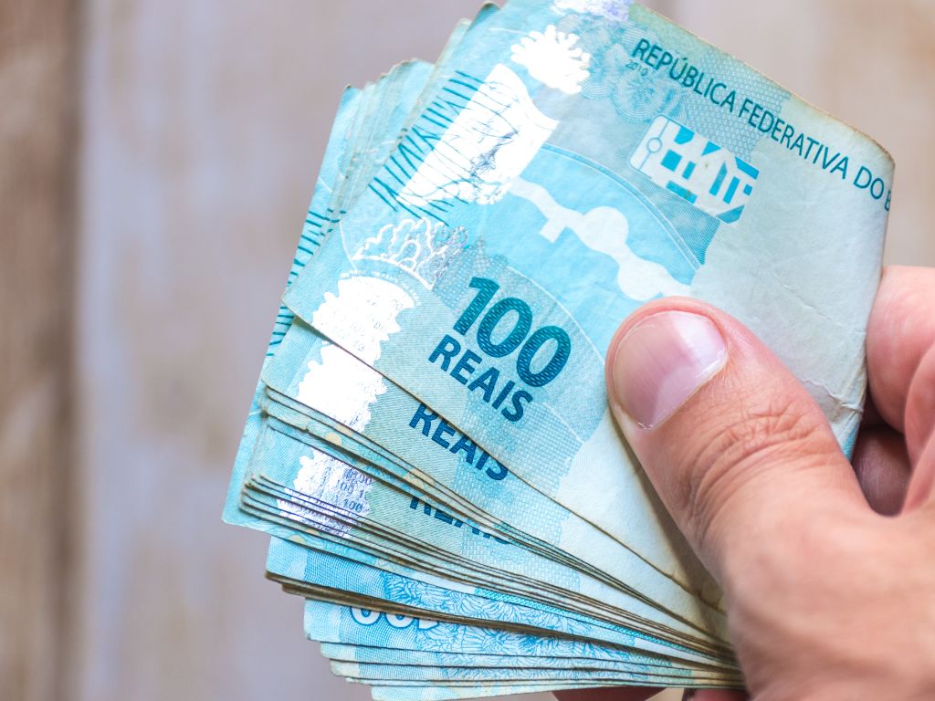 mão com notas de 100 para praticar fetiche money slave