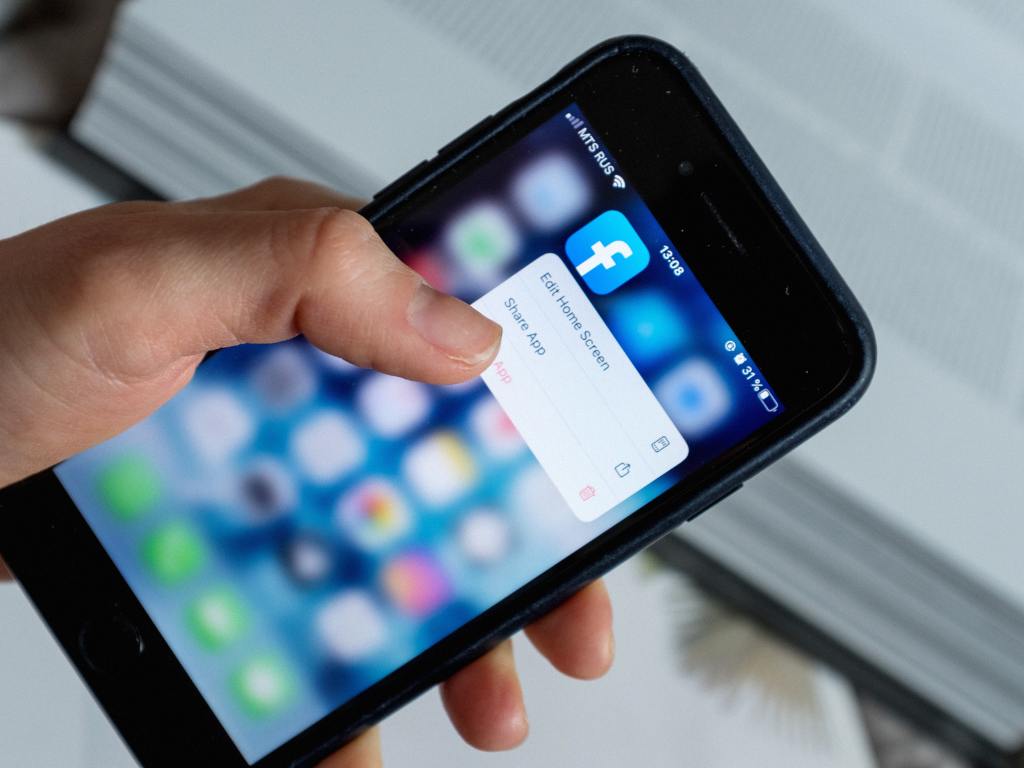 Pessoa com celular na mão entrando no Facebook Namoro