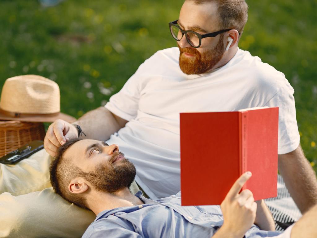 Casal de homens lendo livros juntos