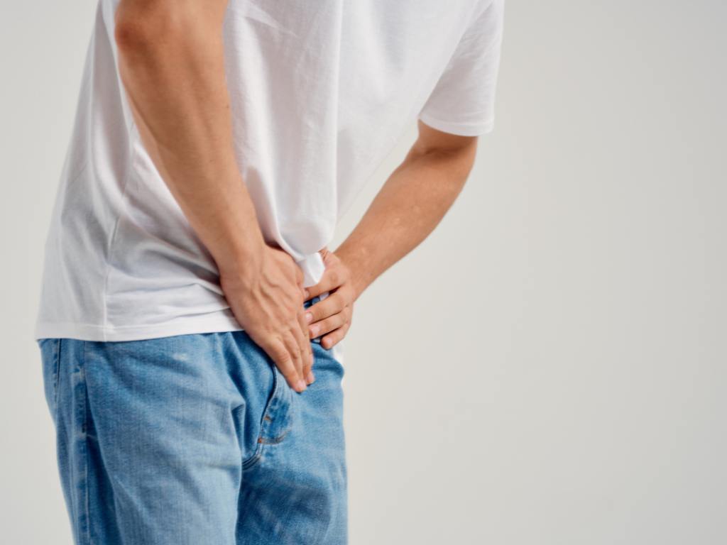 Homem colocando a mão na ereção com dor