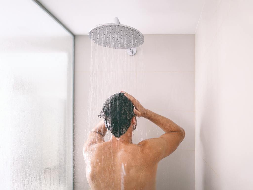 Homem no chuveiro se lavando