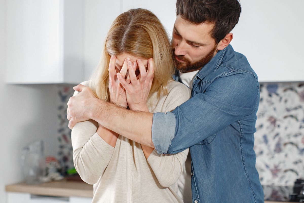 homem abraçando mulher chorando