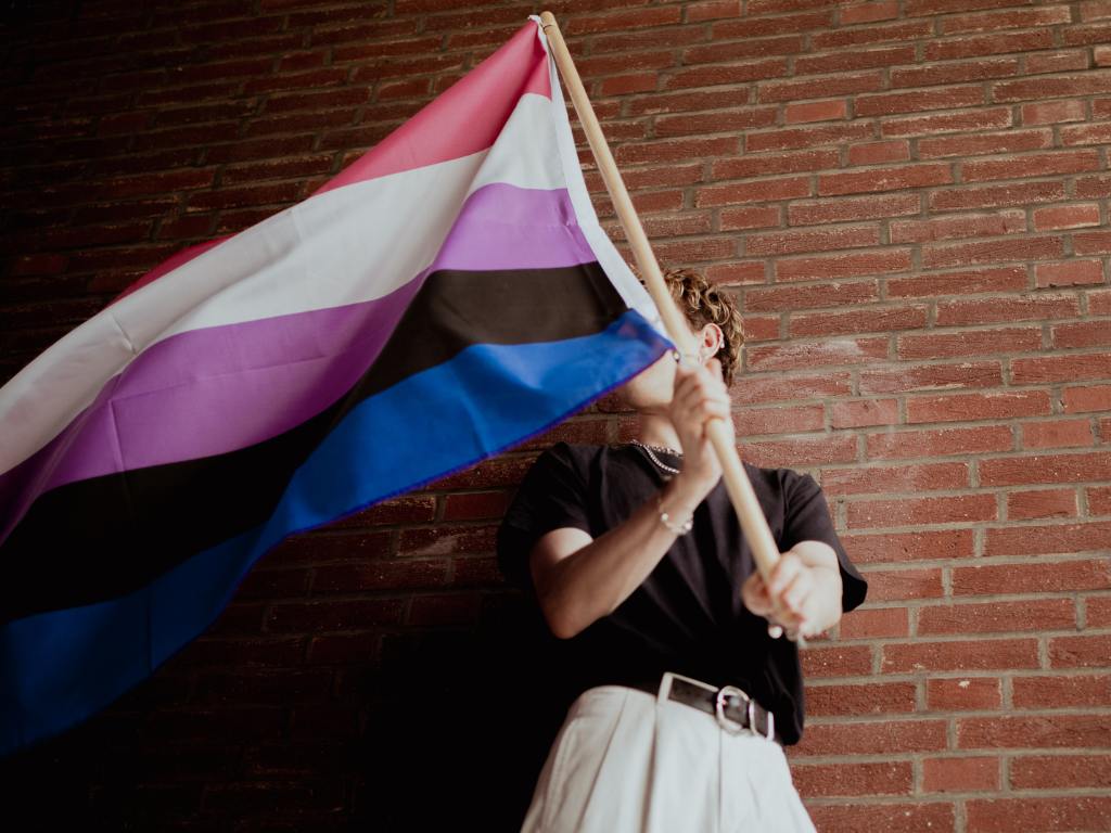 Pessoa segurando a bandeira gênero fluído