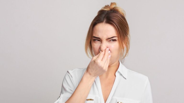 mulher fechando o nariz após sentir cheiro forte na ppk