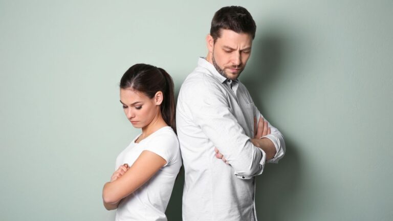 casal de costas um para o outro com expressão triste