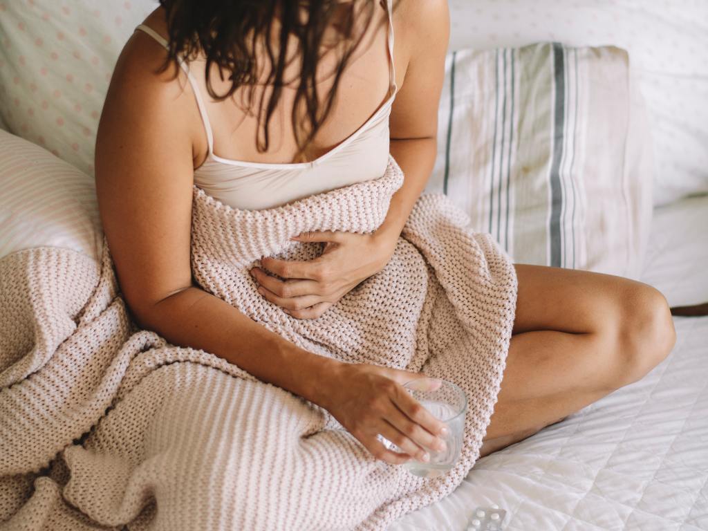 Mulher passando por cólicas na menstruação