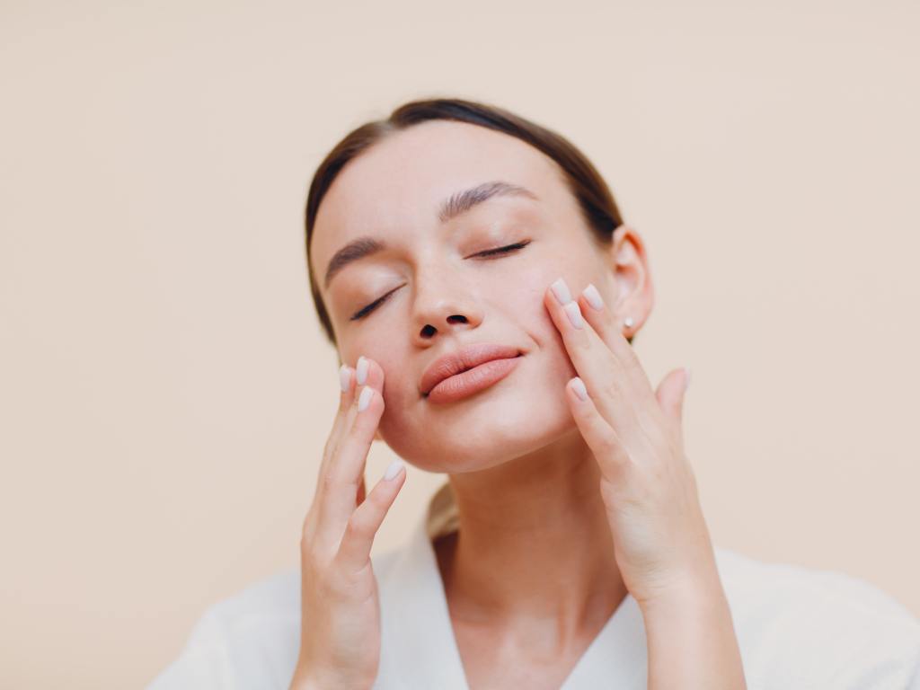 mulher acariciando o próprio rosto fazendo yoga facial