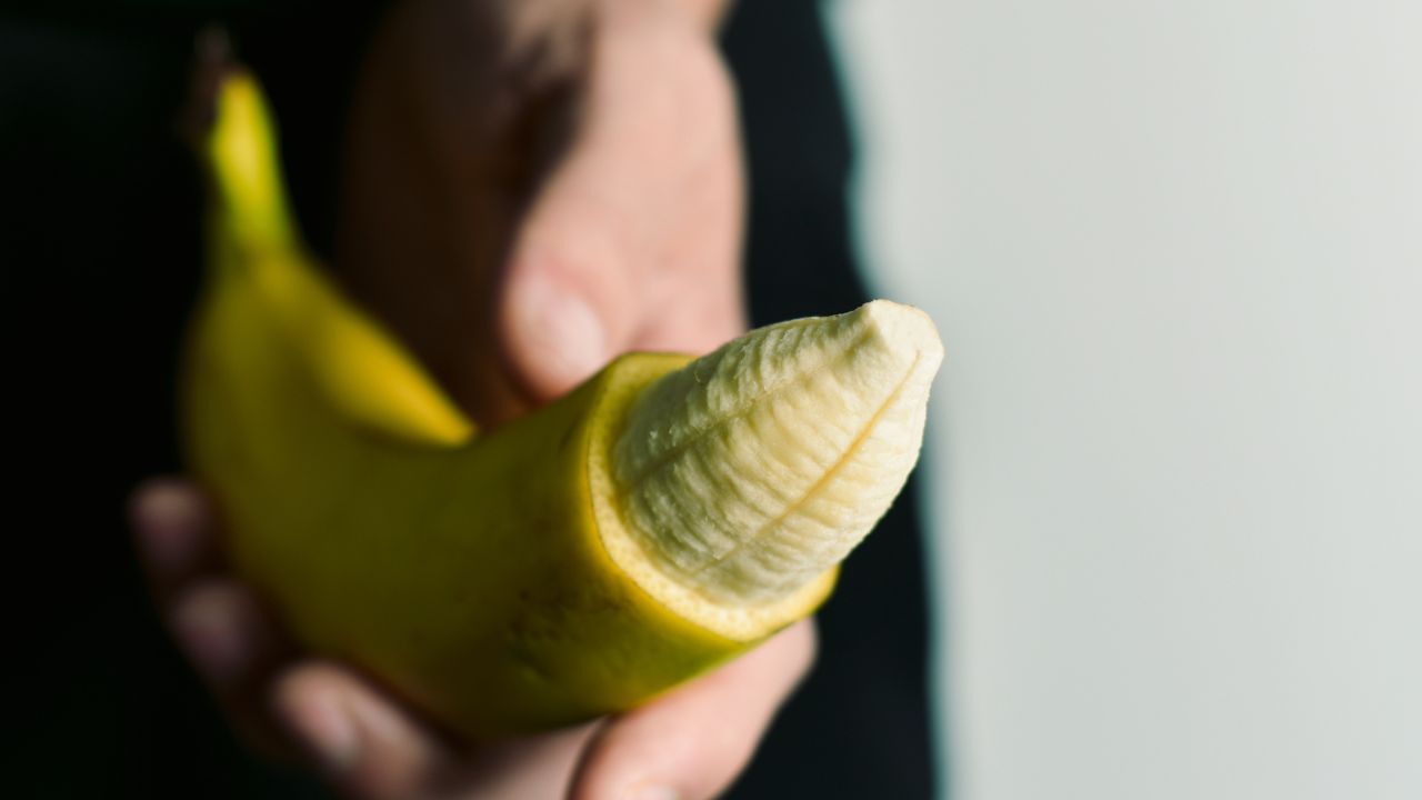homem segurando banana representando pênis