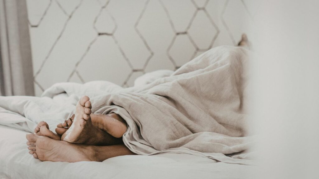 pés de casal na cama entrelaçados