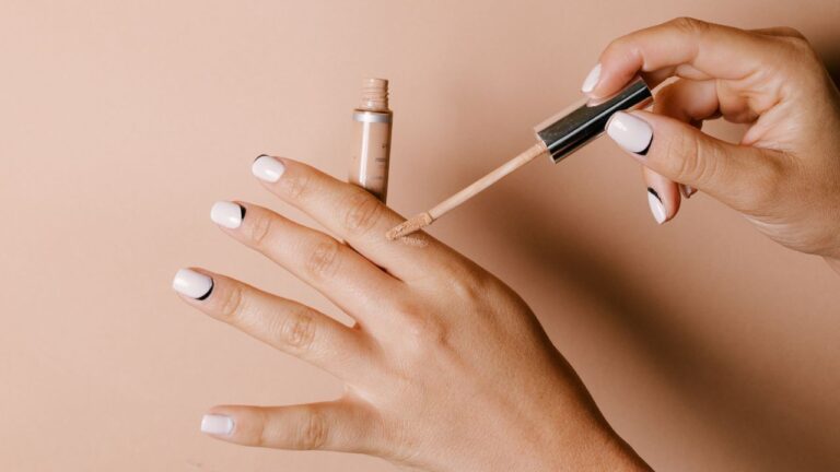 mulher testando o tom do corretivo bom e barato na mão