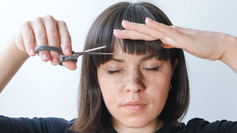 mulher cortando franja em casa