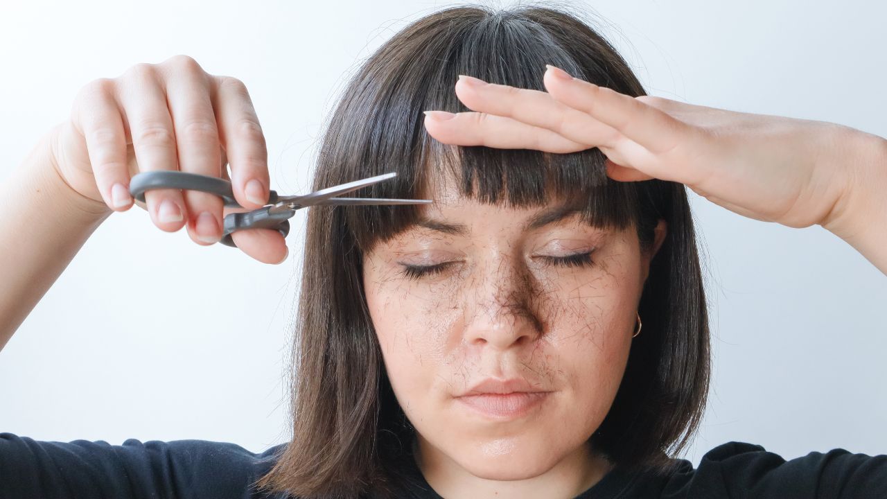 mulher cortando franja em casa